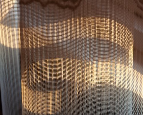 Bright natural light entering a home office through sheer curtains